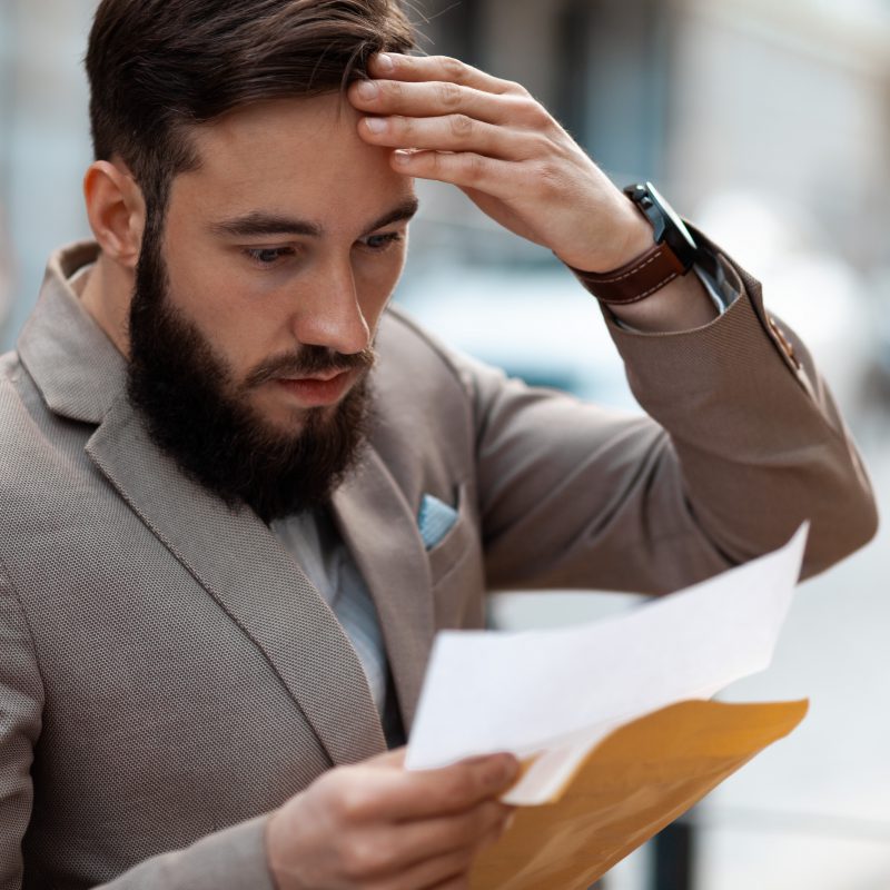 Business owner trying to understand how to minimize its business tax liability. A shocked man realizing how many taxes he must pay