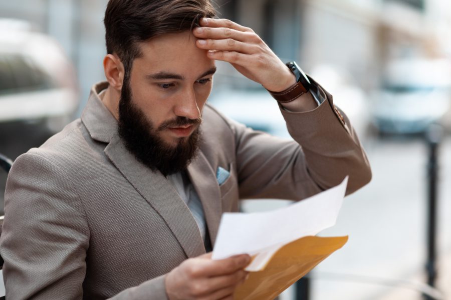 Business owner trying to understand how to minimize its business tax liability. A shocked man realizing how many taxes he must pay